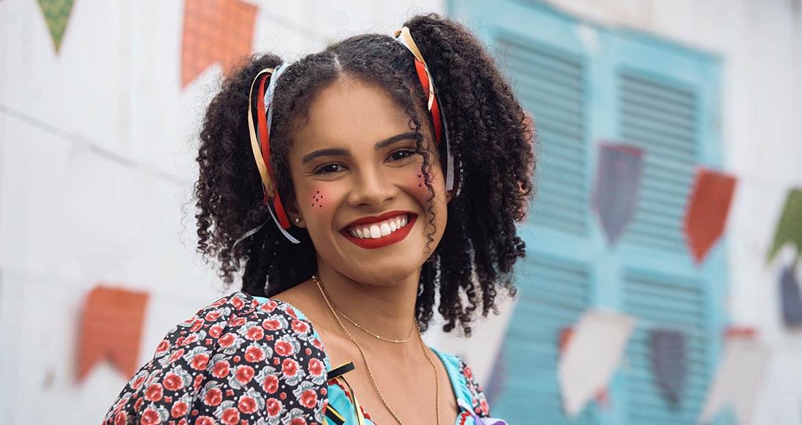 mulher negra com cabelo crespo com penteados de maria chiquinha preso com fitas de cetim